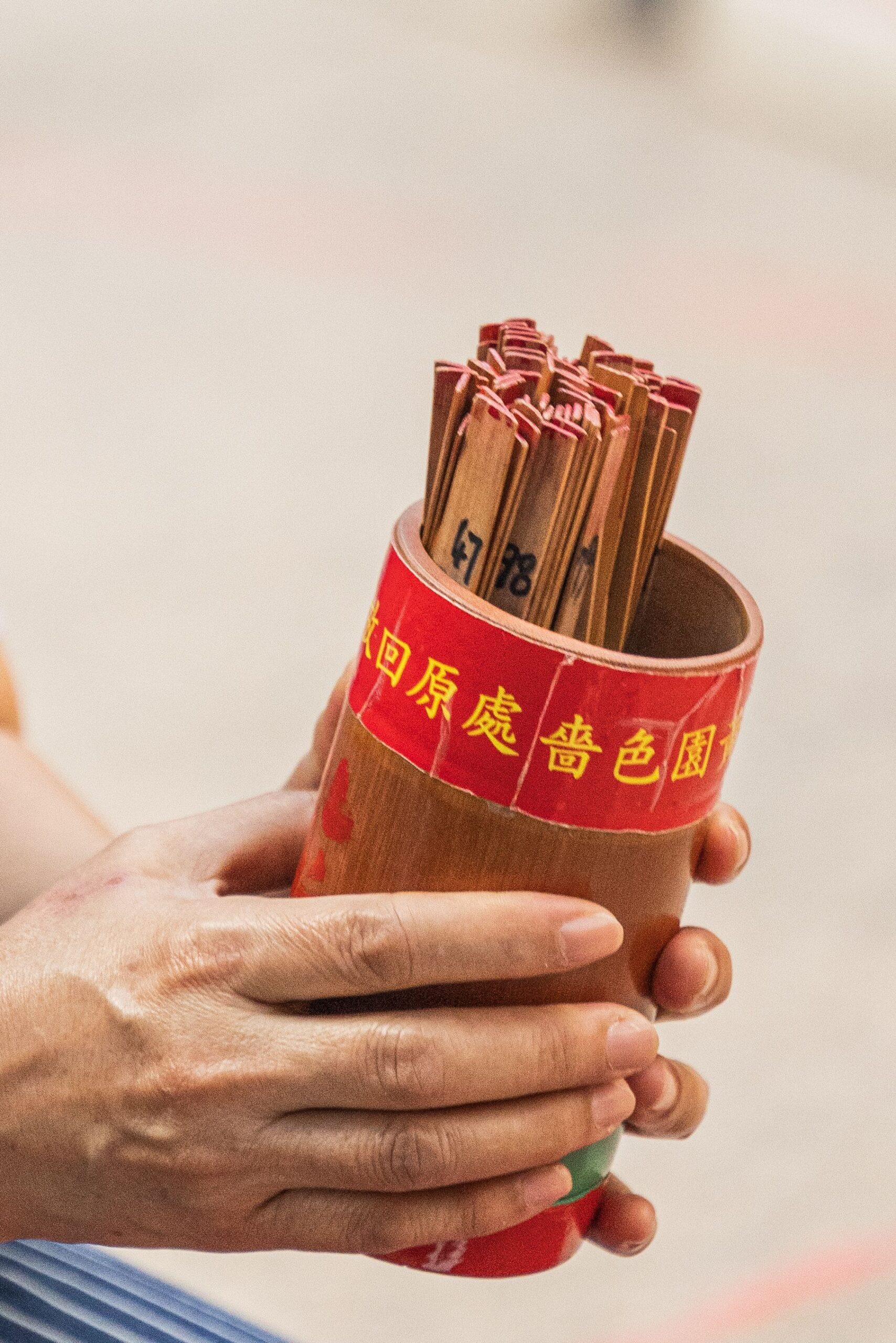 Hands holding Chinese fortune telling sticks for fortune telling singapore
