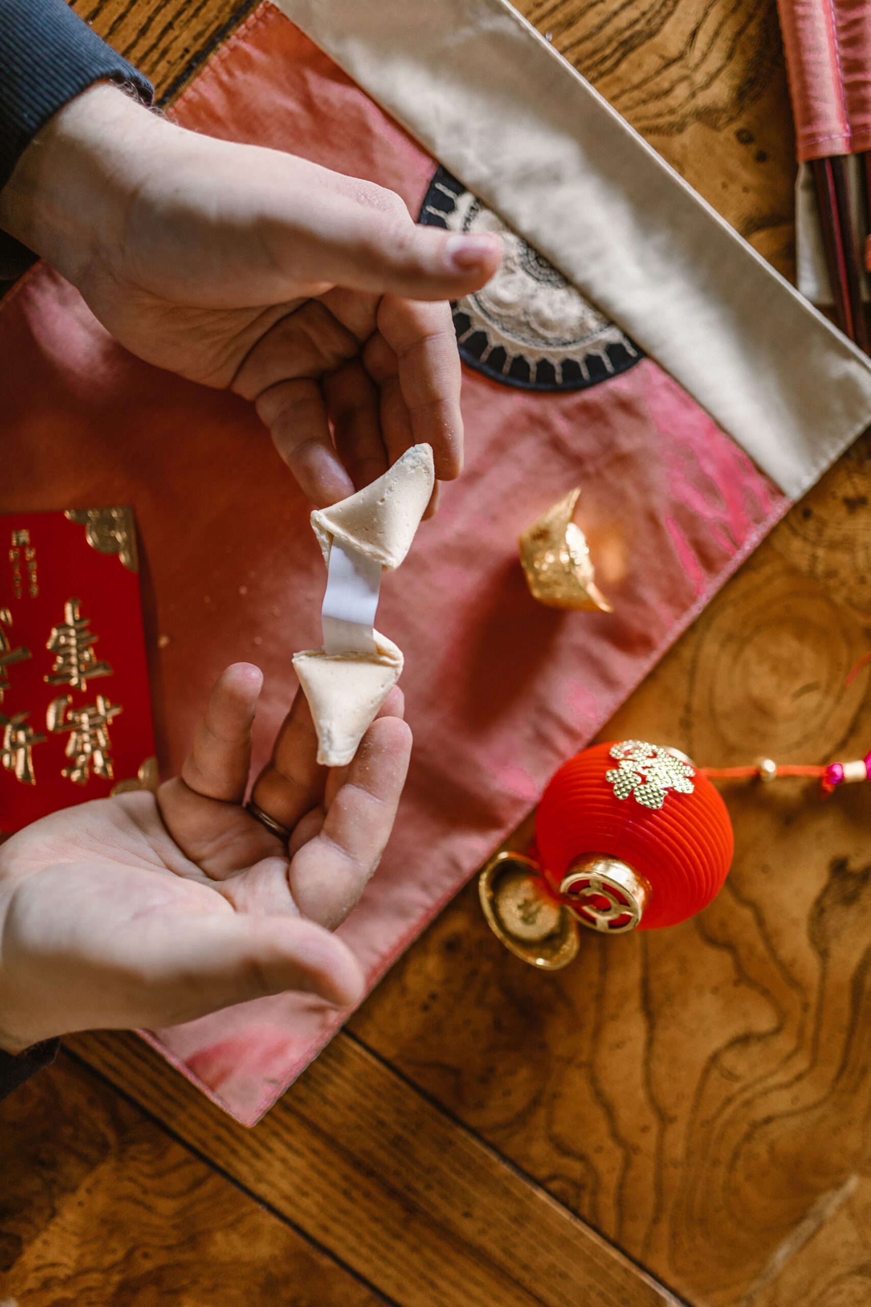 Hands holding a fortune cookie representing fortune telling singapore traditions